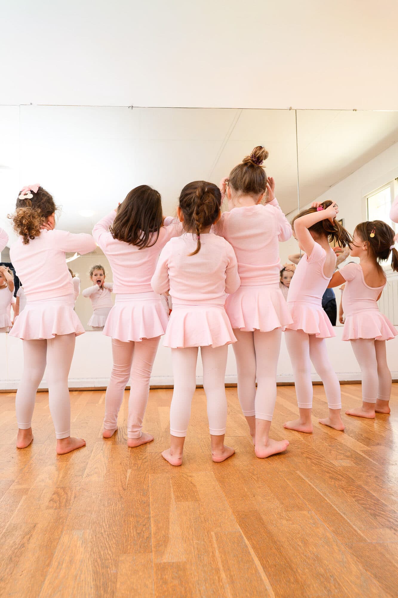 Jeunes enfants en tenue de danse à la barre, vus de dos
